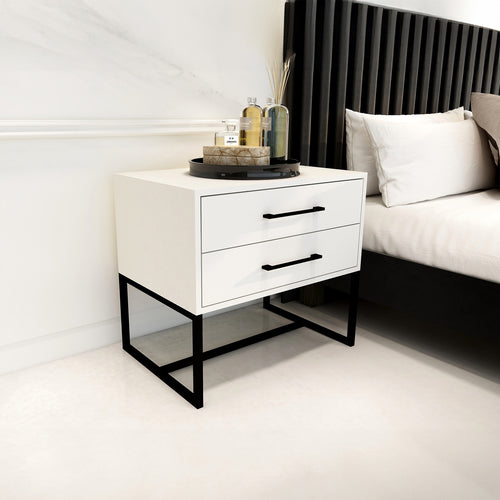 White nightstand with black legs next to a bed in a bedroom setting