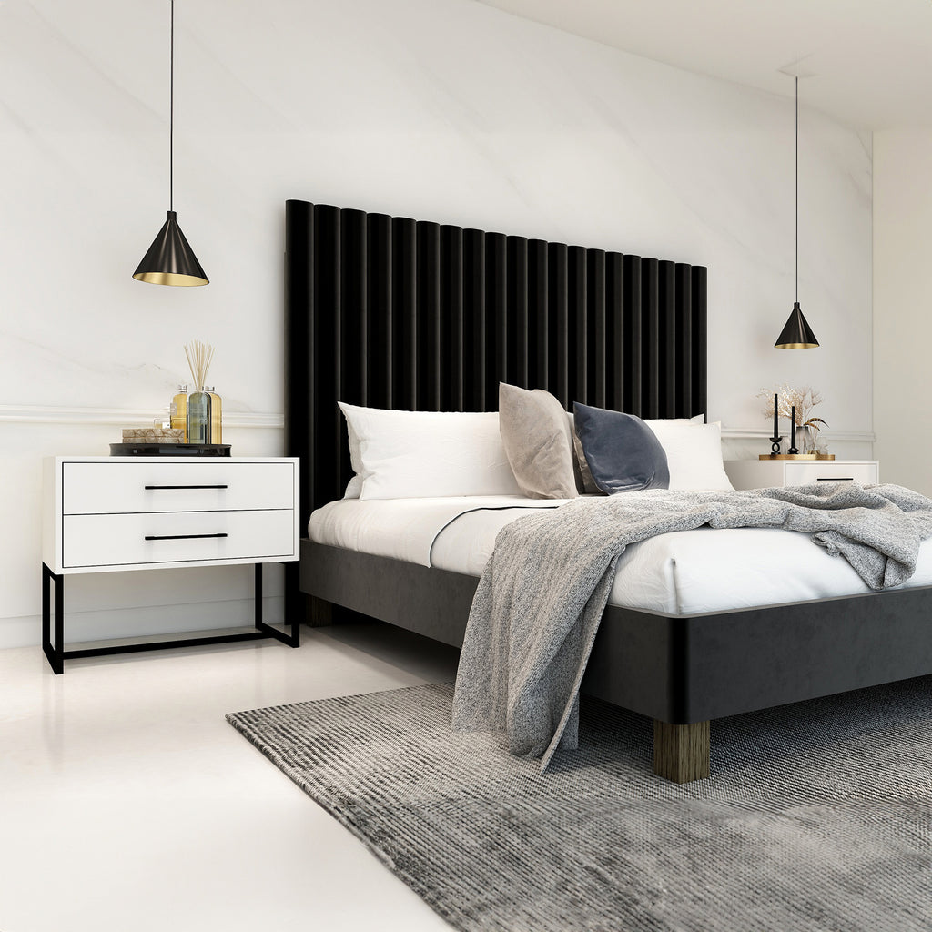 Modern bedroom with a black upholstered bed, white nightstands, and decorative elements.